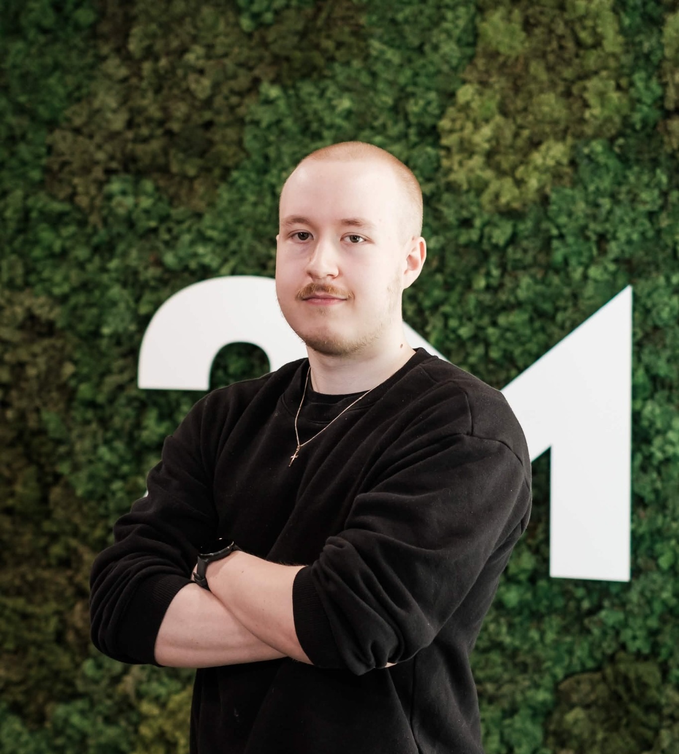 Juuso Mantere standing in front of a green wall